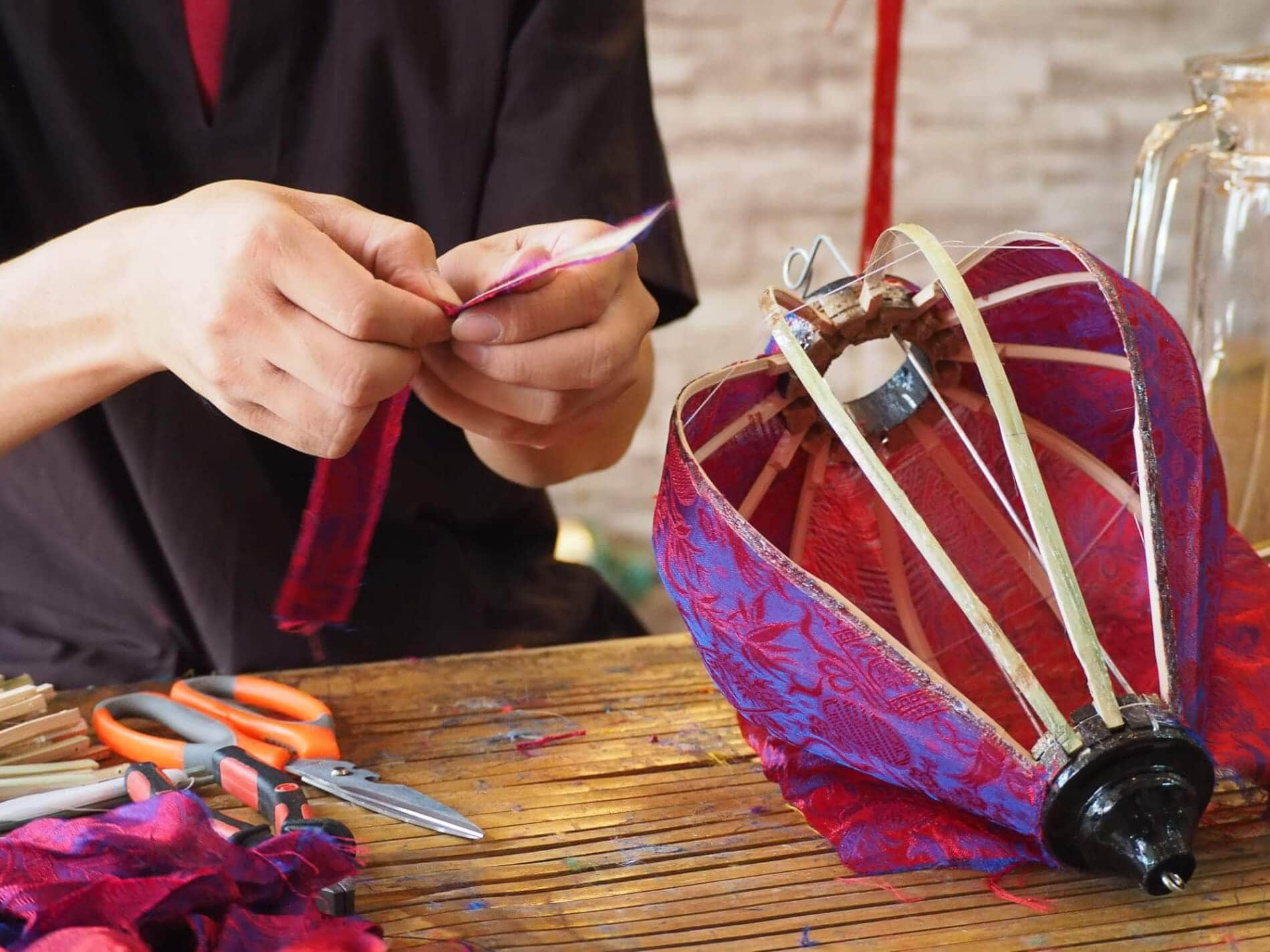 Travelers enjoy a hands-on lantern-making session as the rain taps softly on the workshop roof